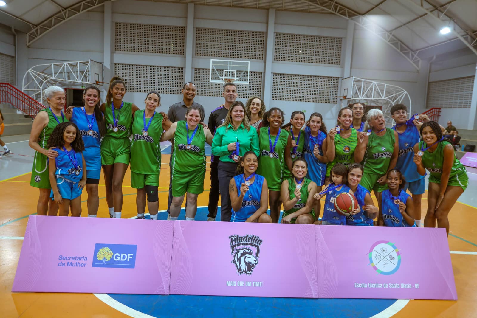 Equipe feminina da Filadélfia reunida em quadra com medalhas após a competição